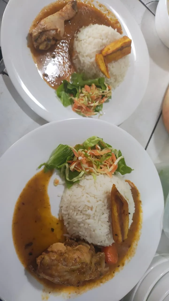 Platos de almuerzo casero con arroz, pollo, ensalada y maduro